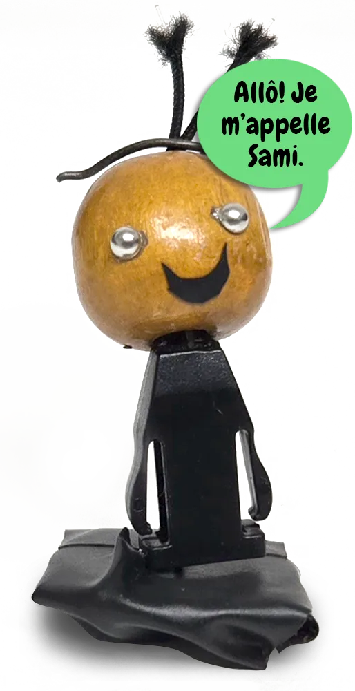 Une figurine bricolée à la main avec une tête jaune et des antennes qui dit : « Salut! Mon nom, c’est Sami! »